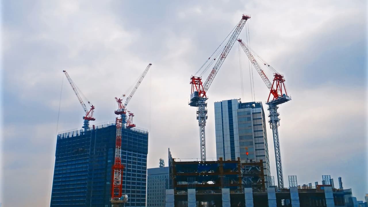 رافعات برجية فوق مبان معاصرة قيد الإنشاء.
